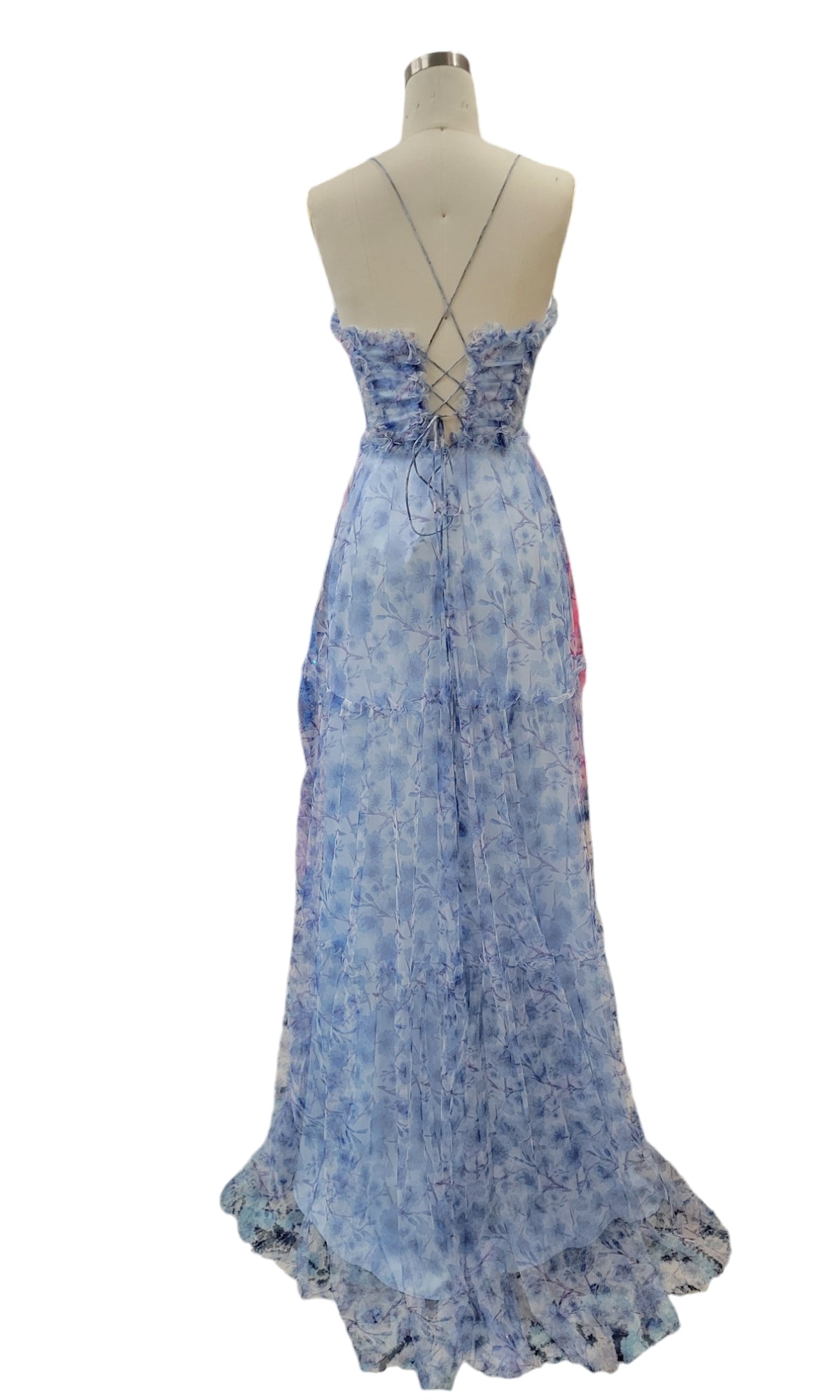 Back view of the Dave and Johnny 12077 blue floral prom dress with an A-line skirt, ruffled hem, and crisscross lace-up open back, shown on a dress form.